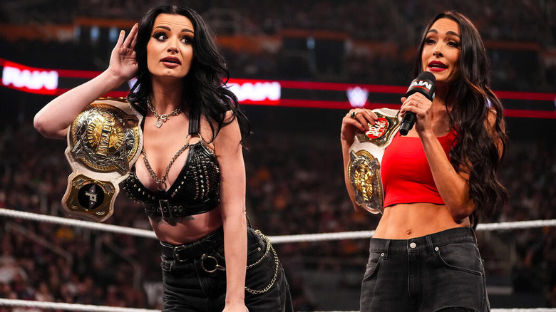 Paige and Brie Bella stand in the ring with their titles on "WWE Raw"