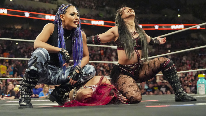 Giulia and Roxanne Perez crouch over Iyo Sky