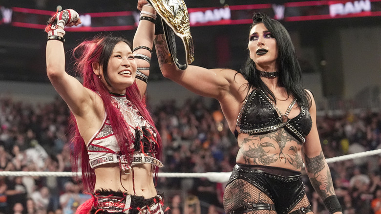 IYO SKY celebrates while Rhea Ripley eyes her world title belt on "WWE RAW"