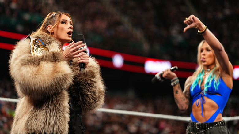 Becky Lynch speaks into a microphone while Sol Ruca mocks her on "WWE Raw"