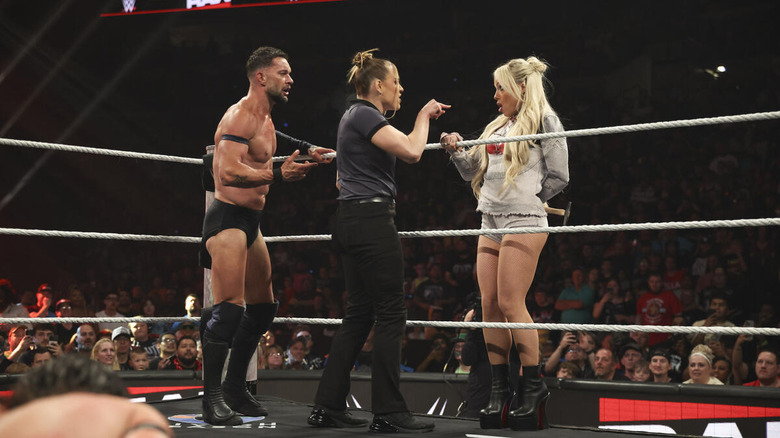 Liv Morgan tries to hide a hammer from Finn Balor and referee Jessika Carr on "WWE Raw"