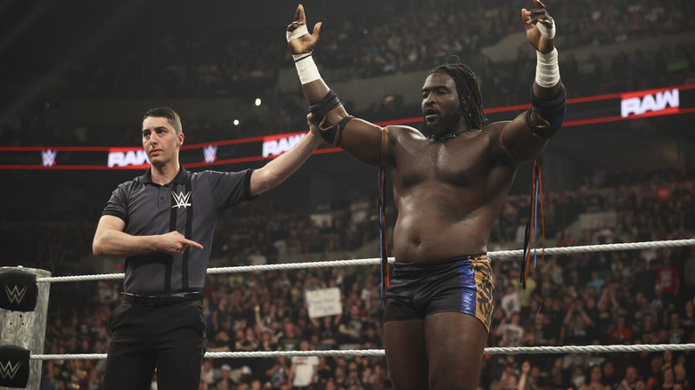 Referee raises Oba Femi's arm as he poses on "WWE Raw"