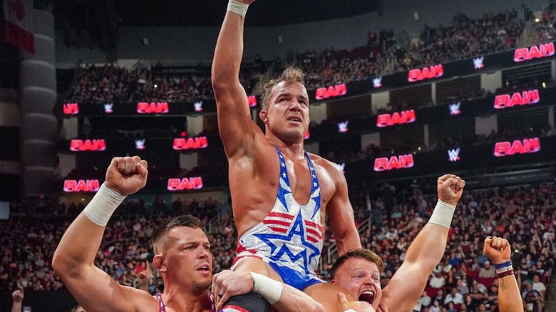 Chad Gable poses, perched on the shoulders of the Creed Brothers, after a victory over Otis in December 2024 on "WWE Raw."