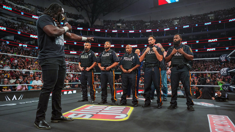 A line of police stand between Oba Femi and Brock Lesnar and Paul Heyman on "WWE Raw"