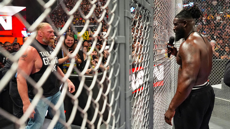 Brock Lesnar and Oba Femi stare each other down on opposite sides of the Hell in a Cell cage on "WWE Raw"