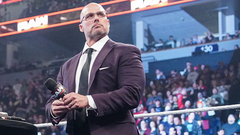 Adam Pearce holds a Raw microphone