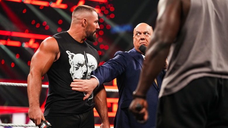 Paul Heyman puts a hand on Bron Breakker while Oba Femi stands nearby on "WWE Raw"