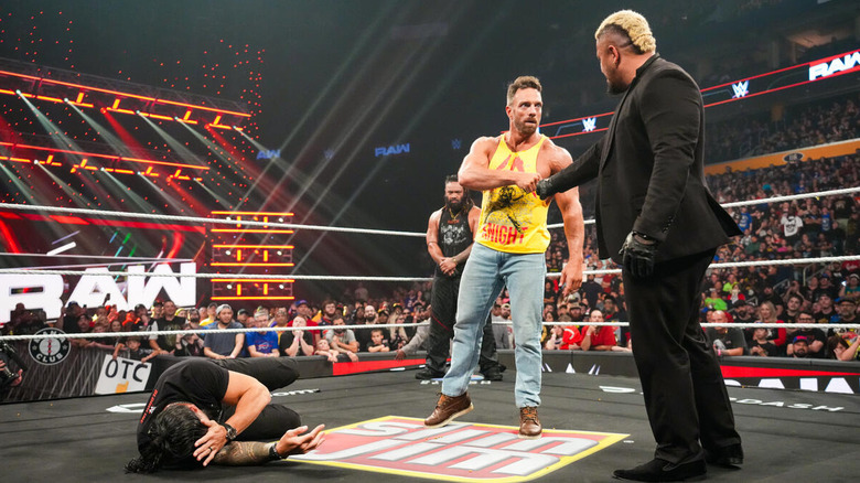 Solo Sikoa and LA Knight fist bump above fallen Roman Reigns in the ring while Jacob Fatu watches on "WWE Raw"