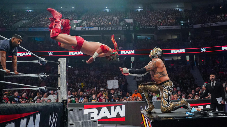 Dragon Lee dives out of the ring at Rey Fenix on the announce table on "WWE Raw"