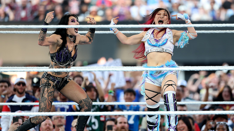 Rhea Ripley and Iyo Sky celebrate a takedown of Naomi during their WWE 2025 SummerSlam Triple Threat match at MetLife Stadium on August 03, 2025 in East Rutherford, New Jersey.