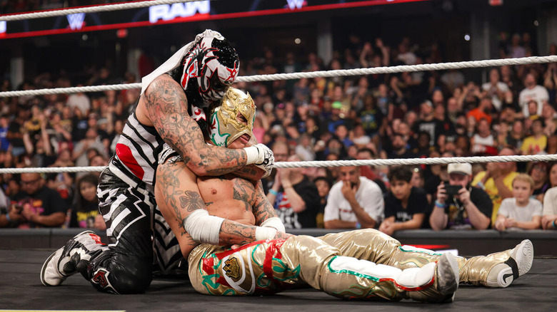 Penta cradles the fallen form of his brother Rey Fenix in the ring on "WWE Raw"