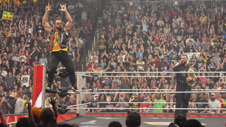 LA Knight poses on the ropes while Roman Reigns looks on on "WWE Raw"