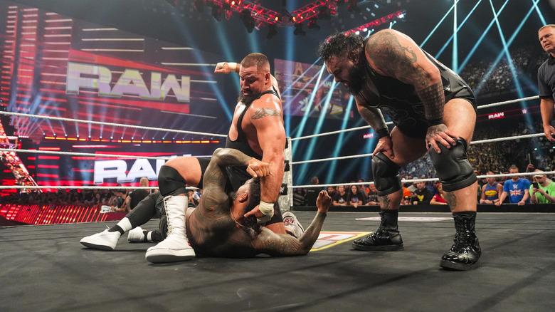 Bron Breakker vence a Jey Uso, mientras Bronson Reed mira.
