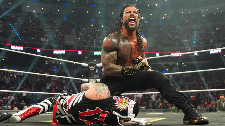 Roman Reigns snarls while standing above a fallen Penta in the ring on "WWE Raw"