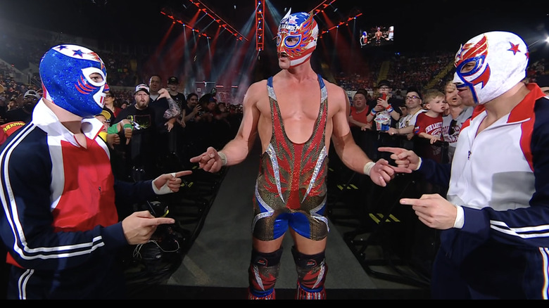 Three masked El Grande Americanos point at each other in confusion, a la Spiderman meme.