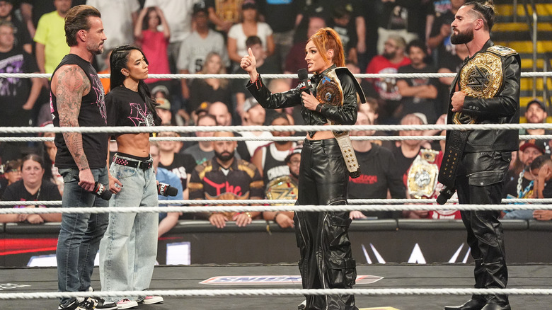 CM Punk and AJ Lee in the ring with Seth Rollins and a speaking and gesturing Becky Lynch on "WWE Raw"
