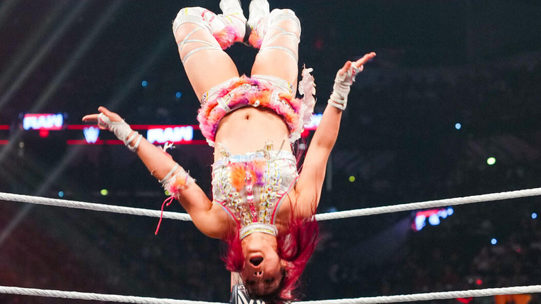 IYO SKY hangs upside down in the air while delivering a moonsault on "WWE Raw"