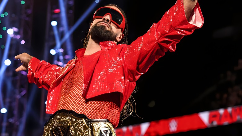 Seth Rollins spreads his arms while wearing shades