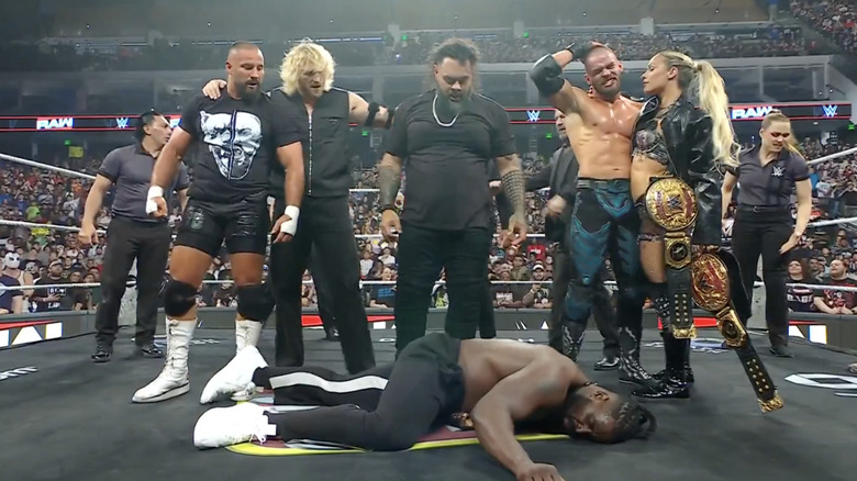 The Vision standing over Femi inside the ring