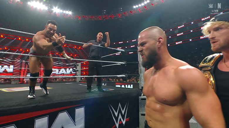 Knight demanding that Theory get back in the ring as Paul stands by