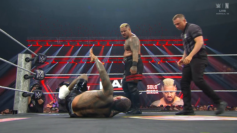 Sikoa standing over Jey inside the ring