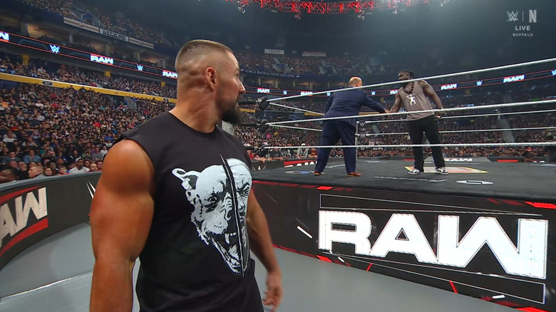 Breakker watching Heyman and Femi shake hands in the ring