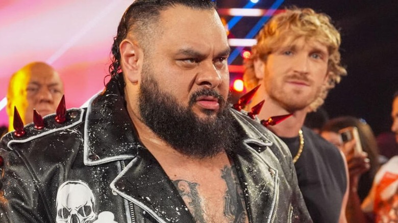 Bronson Reed, flanked by Austin Theory, Paul Heyman, and Logan Paul, makes his way down to the ring before a match on 