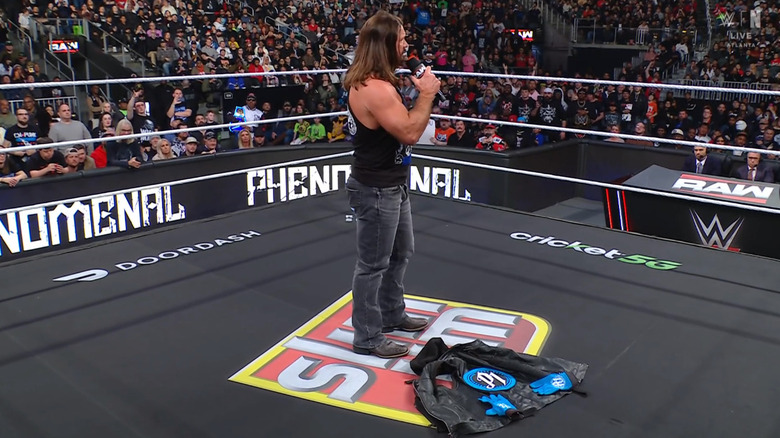 Styles standing over his vest and gloves