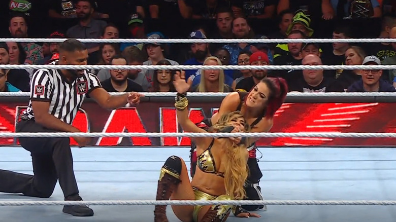 Bayley locking in a chin lock on Aliyah