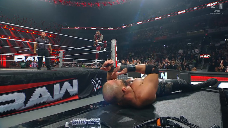 Jimmy ascending to the top rope as Theory lays on the announce desk