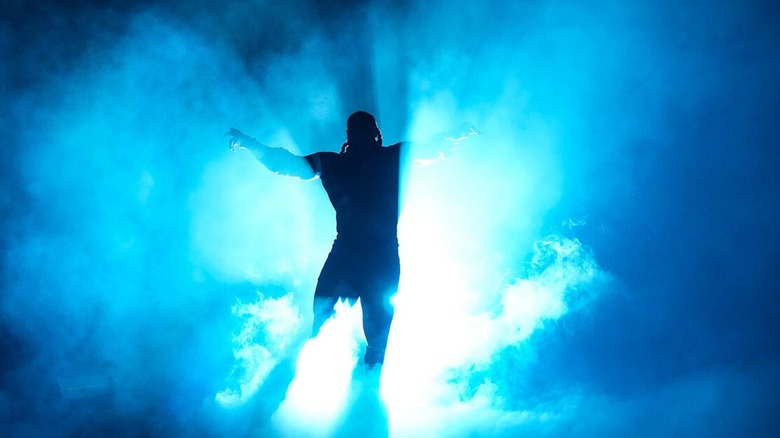 Oba Femi poses in blue light on "WWE Raw"