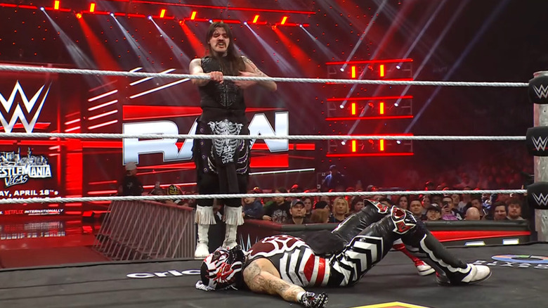 Dominik standing on the ring apron with Penta in the ring
