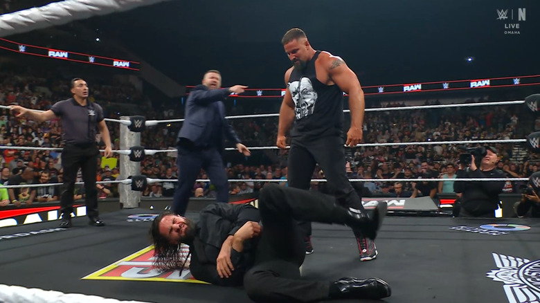 Breakker standing over Rollins