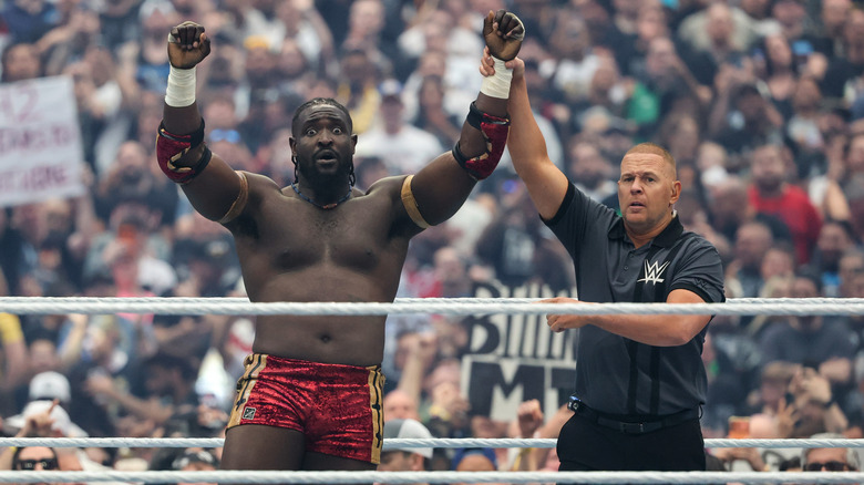 A referee raising Femi's hand