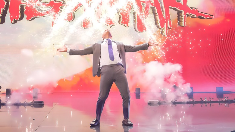 Cody Rhodes leaning back with fireworks behind him