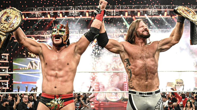 Lee and Styles holding up their World Heavyweight Championship belts