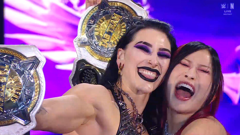 Ripley and SKY hugging on the entrance ramps with their Women's Tag Team Championship belts