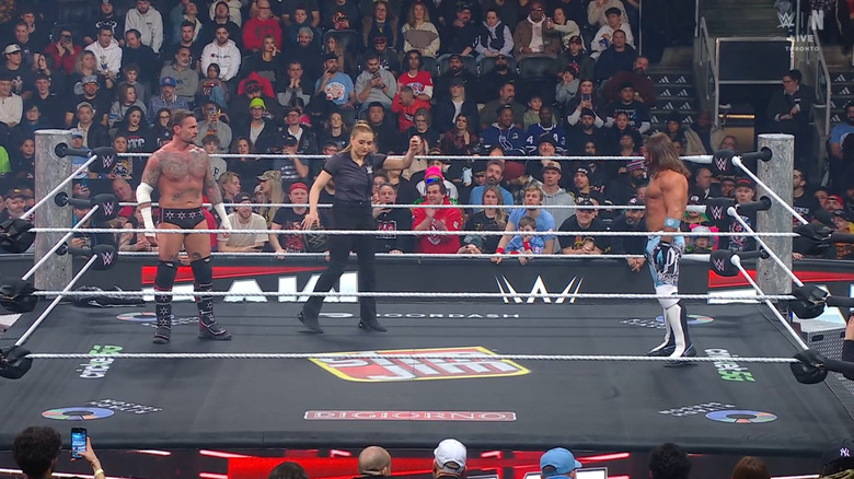 Punk and Styles staring one another down in the ring