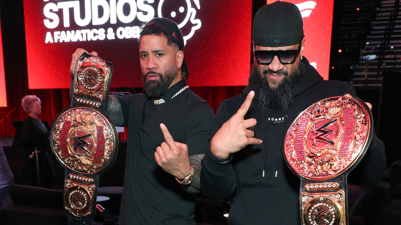 The Usos holding up their World Tag Team Championship belts at an event