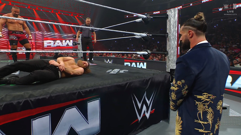 Breakker and Zayn in the ring as Rollins watches from outside the ring