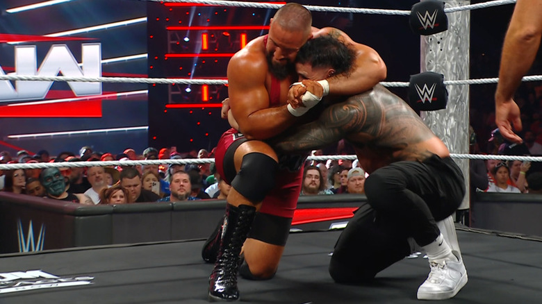 Breakker with a side headlock cinched in on Jey