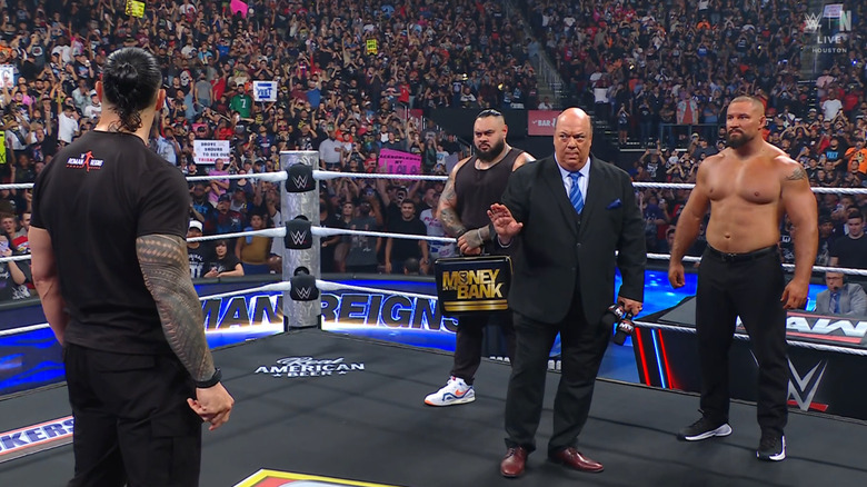 Reigns, Reed, Heyman, and Breakker standing in the ring