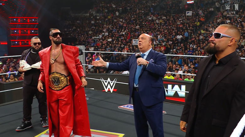 Reed, Rollins, Heyman, and Breakker standing in the ring