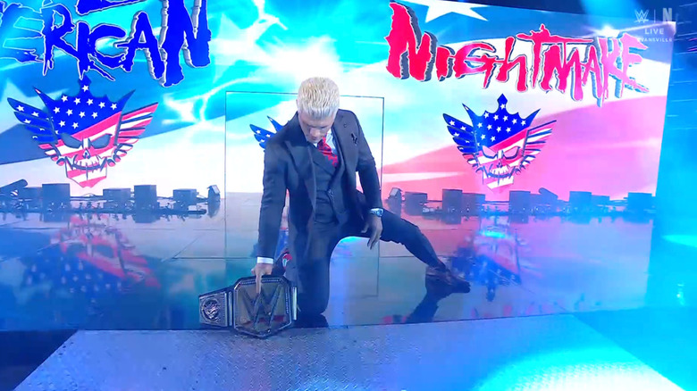 Rhodes kneeling on the entrance ramp next to his Undisputed WWE Championship