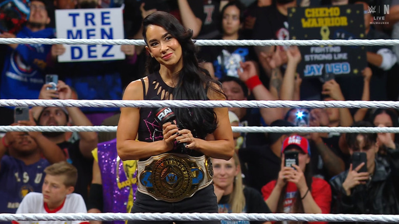 Lee holding a microphone in the ring