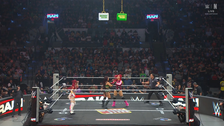 All three women inside the ring with the Money In The Bank briefcases suspended above them