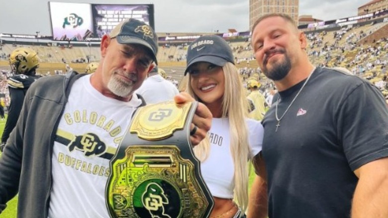 Izzi Dame and Bron Breakker pose with Bill Goldberg at a Colorado Buffalos game.
