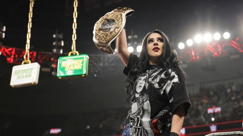 WWE Women's World Champion Stephanie Vaquer holds up the title, the Money in the Bank briefcases looming in the background behind her, during the October 5, 2026 edition of 