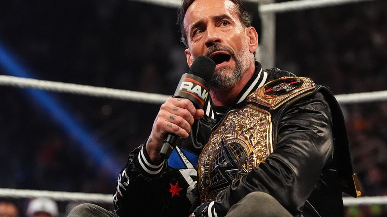 World Heavyweight Champion CM Punk sits cross-legged in the middle of the ring as he cuts a promo in the opening segment of 