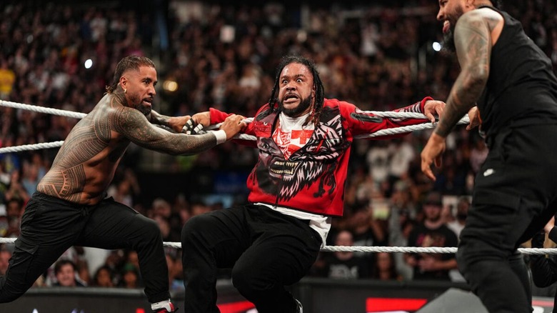 The Usos tie Jacob Fatu in the ropes, allowing for Roman Reigns to attack him, during an episode of 